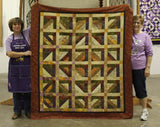 larger quilt made from this pattern done in a brown/gold colorway